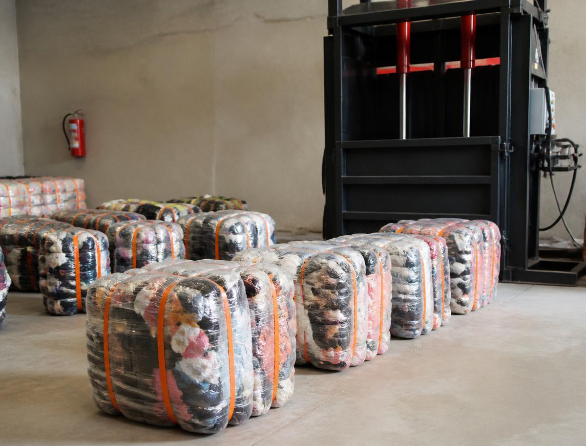 Balles de vêtements compressées, filmées et sanglées d'orange